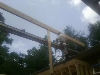 Carpenter setting a ridge beam over a new addition frame — Ice Dam Removal by Roofing Brothers in Oakland City