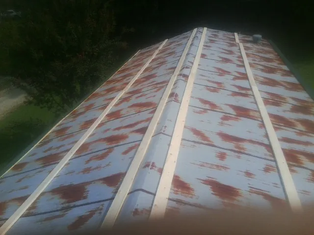 Rusted metal roof panels with new wood purlins before replacement — Storm Damage Roof Repair in Oakland City by Roofing Brothers
