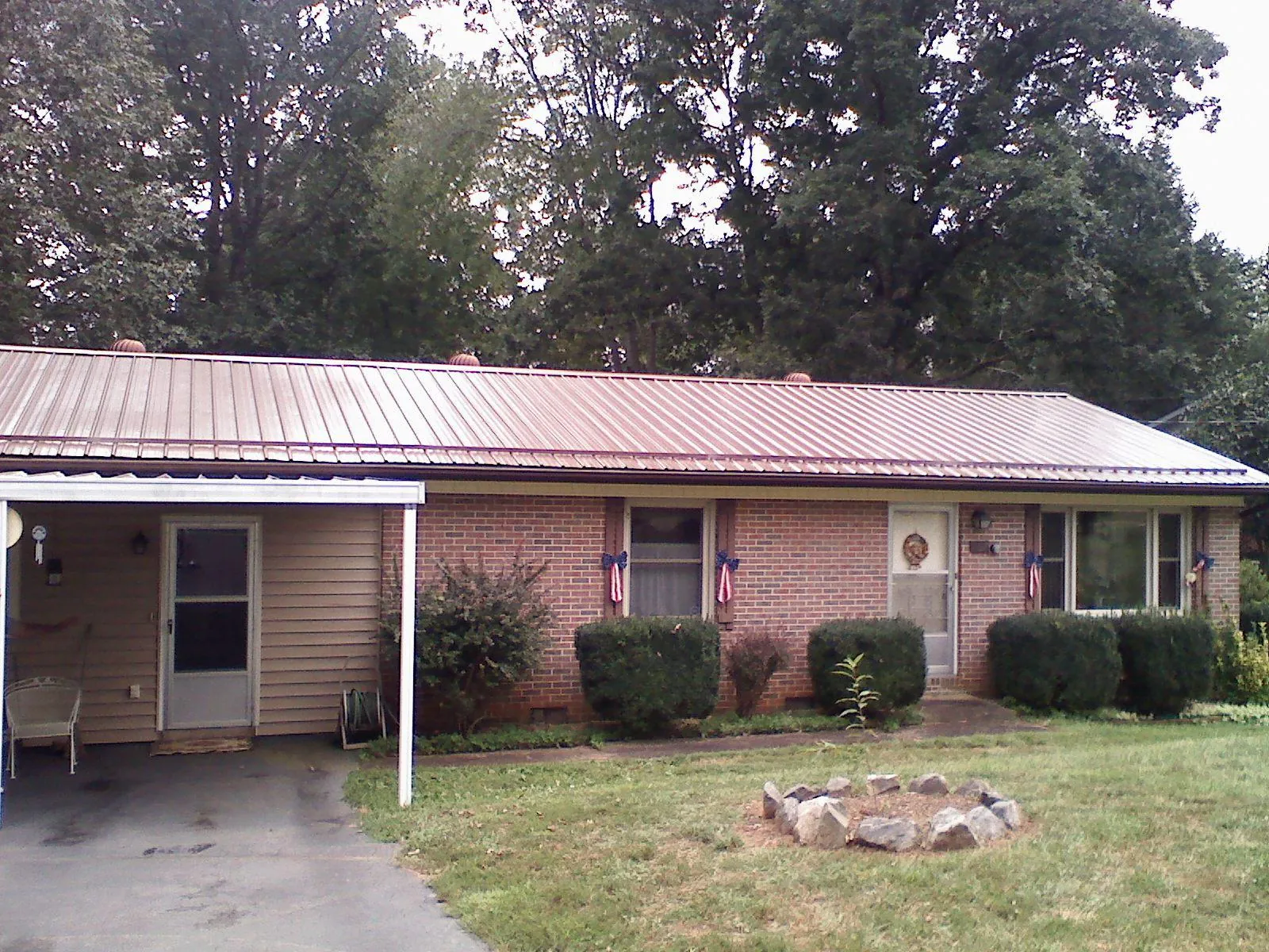 Bronze metal roof and carport on a brick ranch home — Roof Repair work by our crew in Oakland City